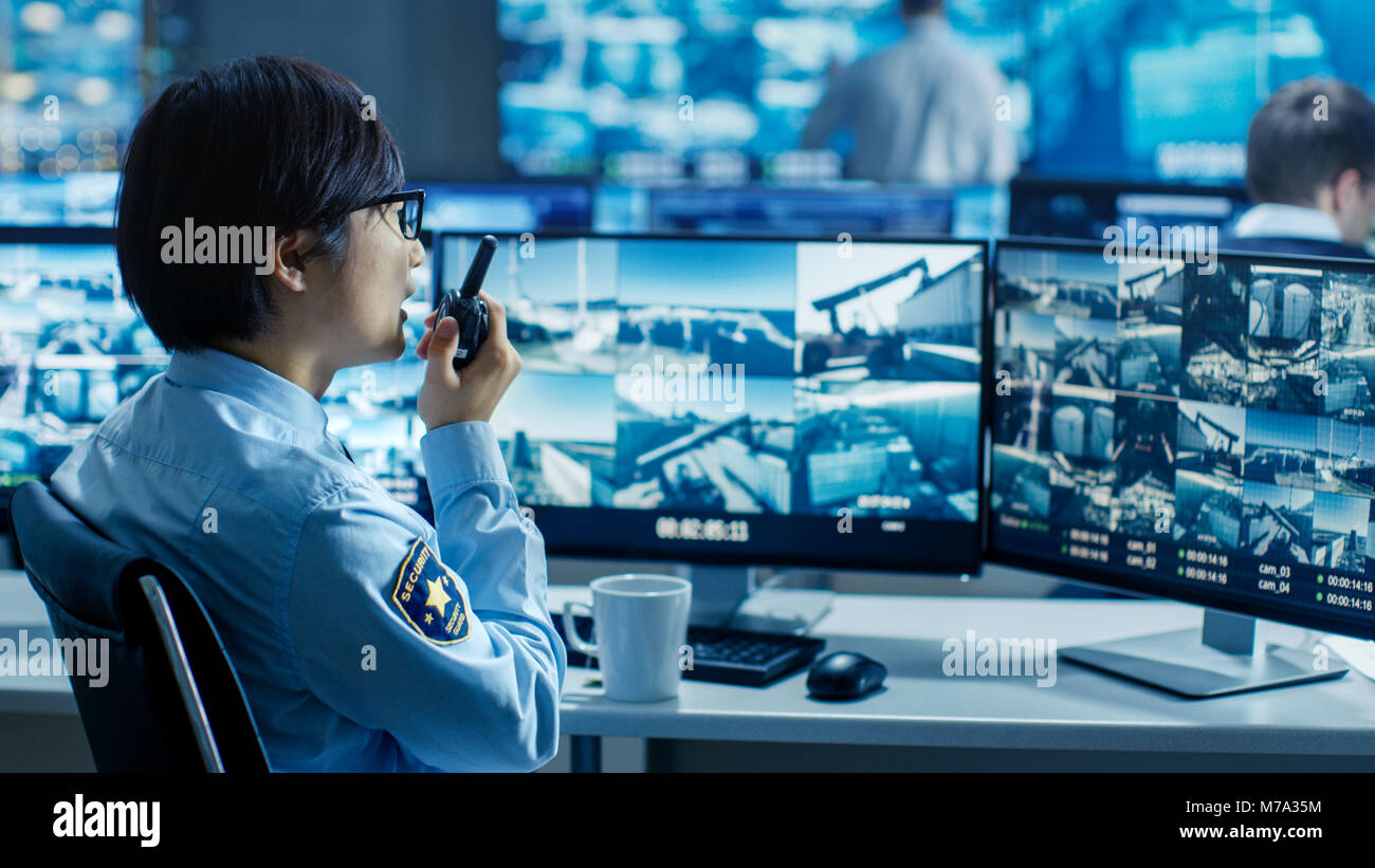 In the Security Control Room Officer Monitors Multiple Screens for