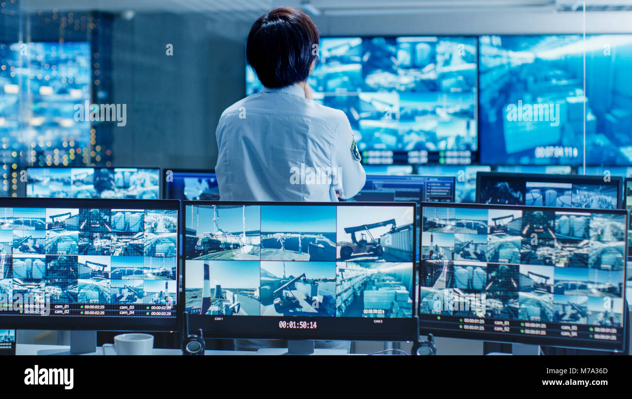 In the Security Control Room Officer Monitors Multiple Screens for
