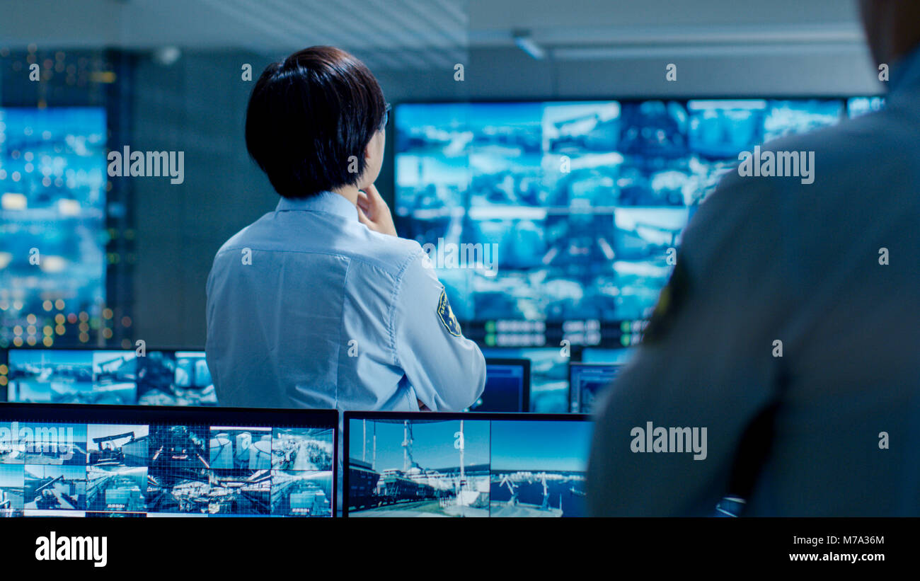 In the Security Control Room Officer Monitors Multiple Screens for