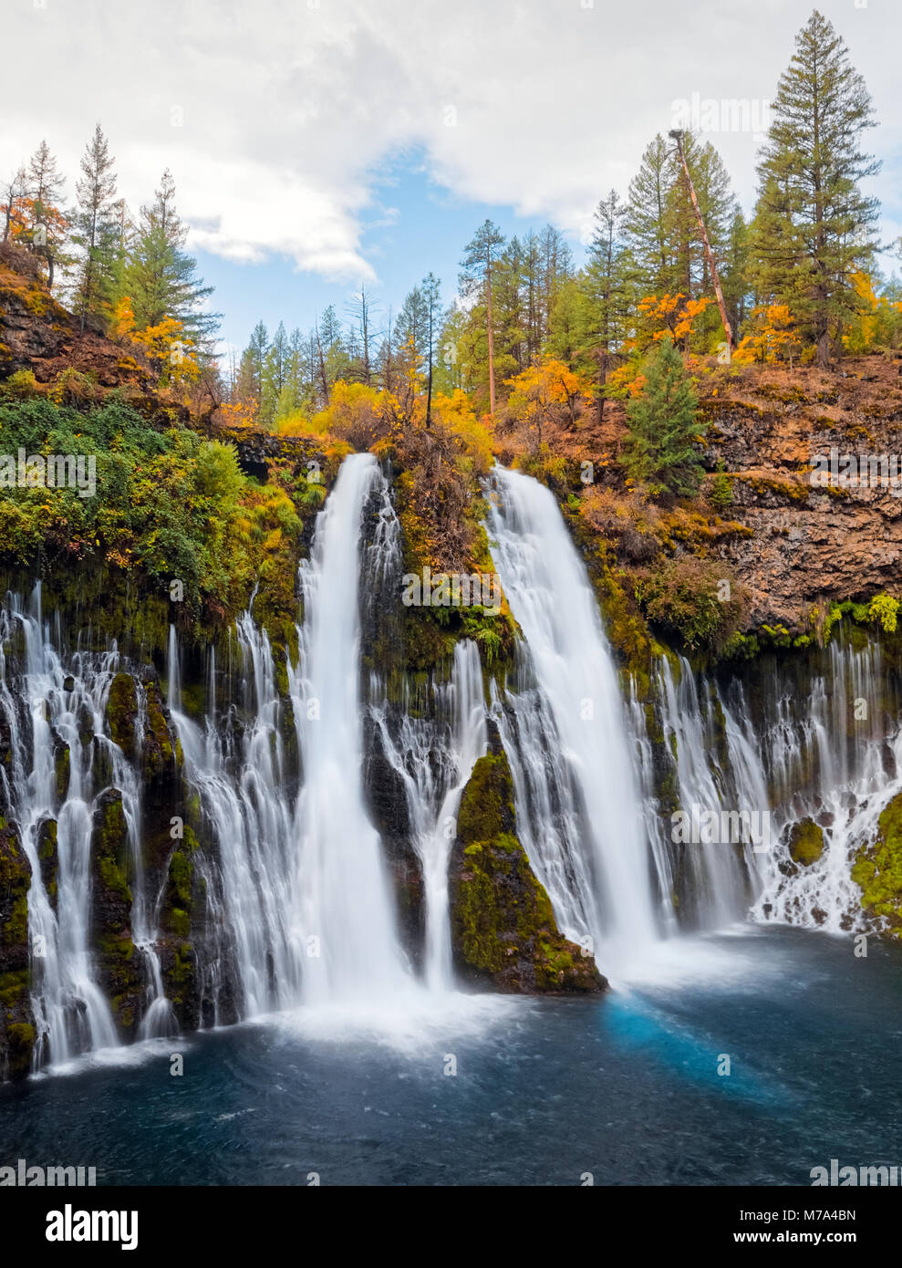 Beautiful waterfall in autumn, with green and yellow trees at McArthur-Burney Falls Memorial State Park, in Shasta County, Northern California. Stock Photo