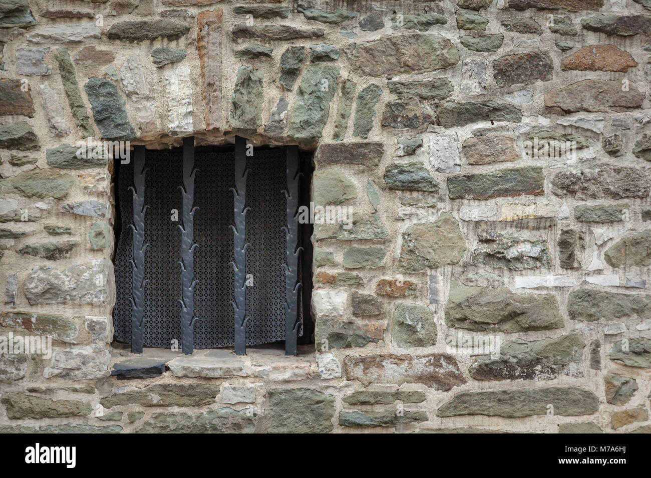 Old stone wall with window with bars Stock Photo - Alamy
