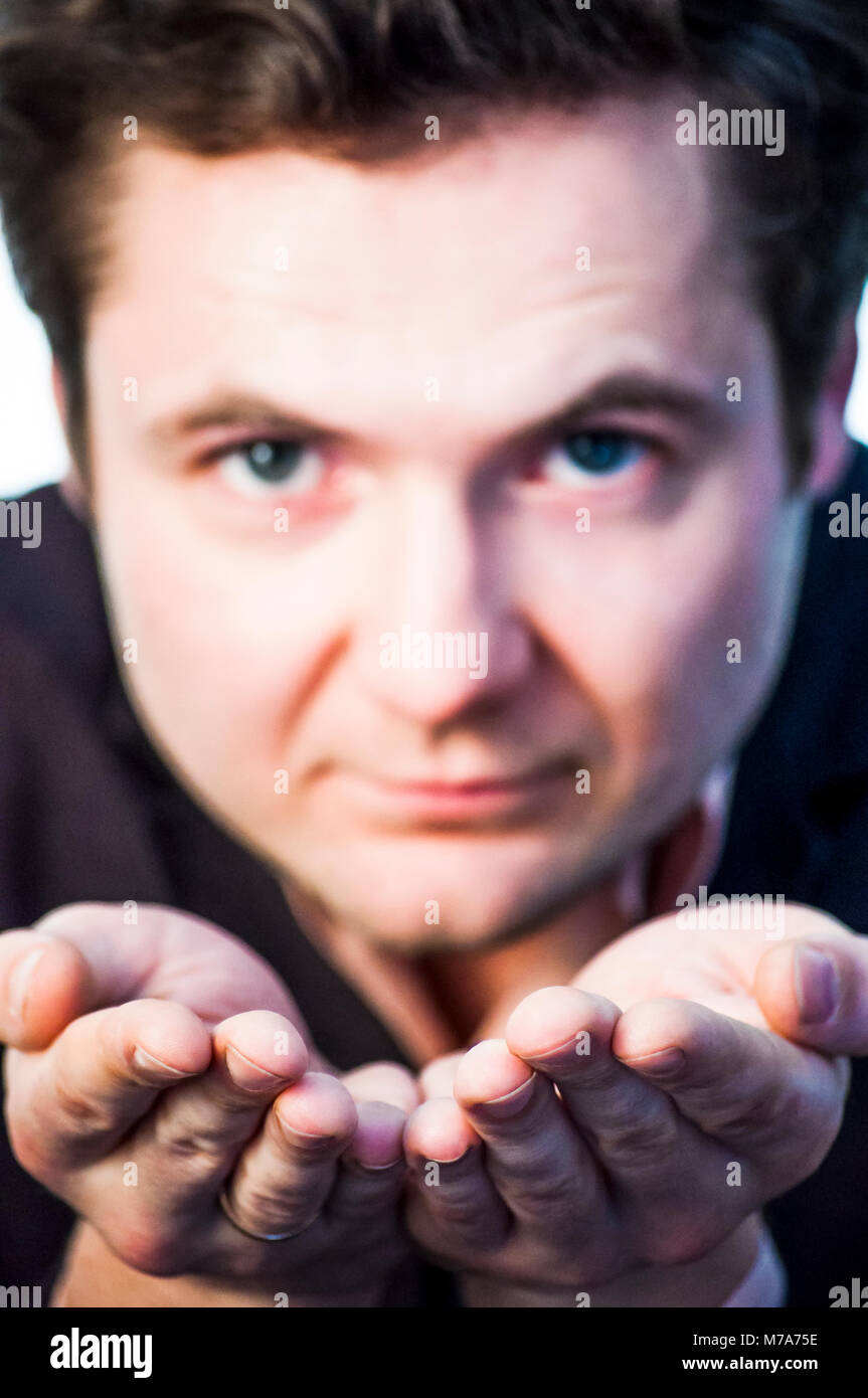 Portrait of young man showing open palms on white background Stock