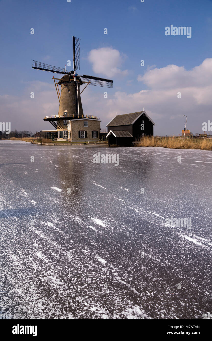 Windmill de Vriendschap at Bleskensgraaf on the banks of the frozen river Graafstroom Stock Photo