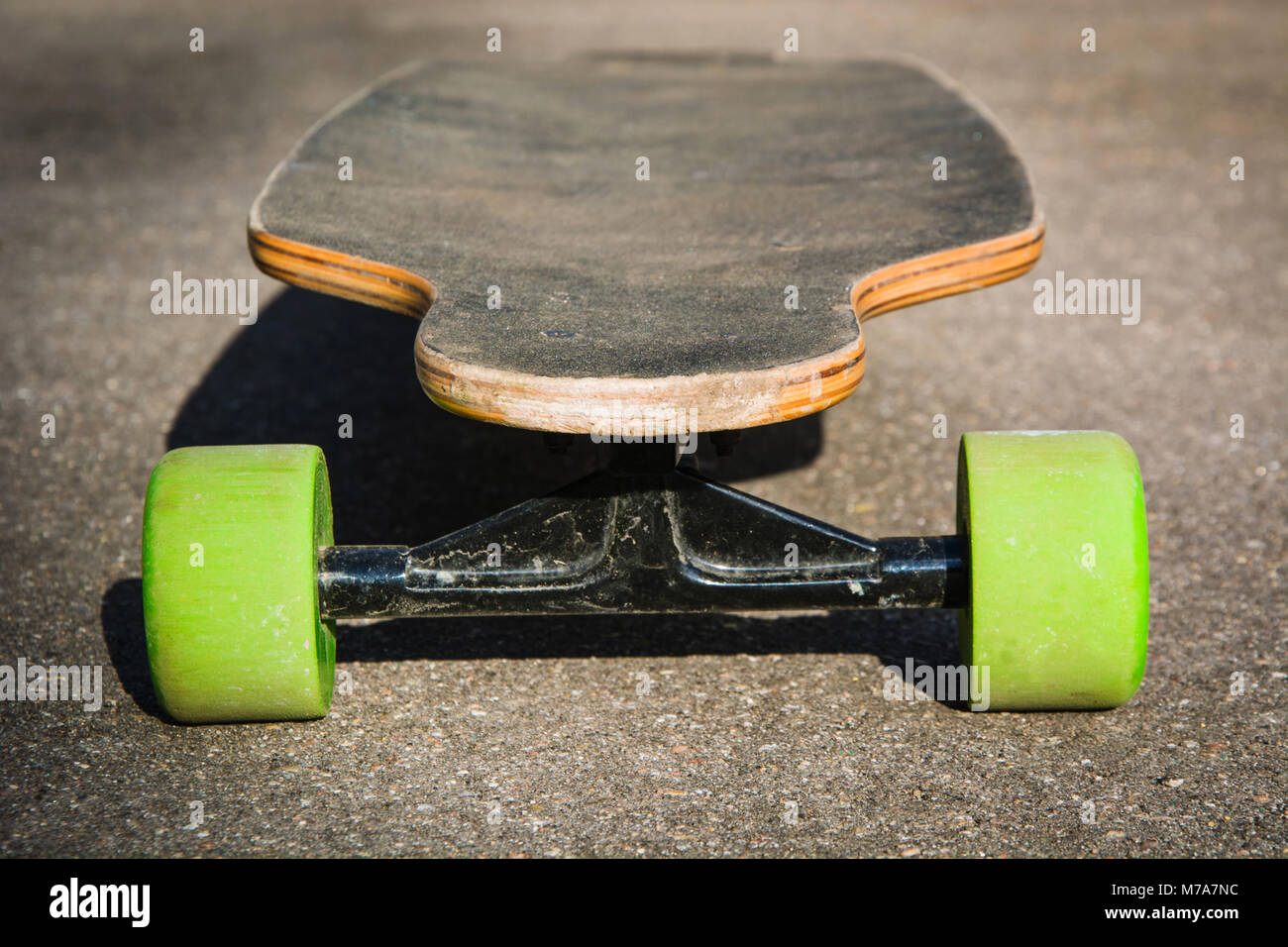 Old used longboard on the ground. Black skateboard on asphalt road. Close  up Stock Photo - Alamy