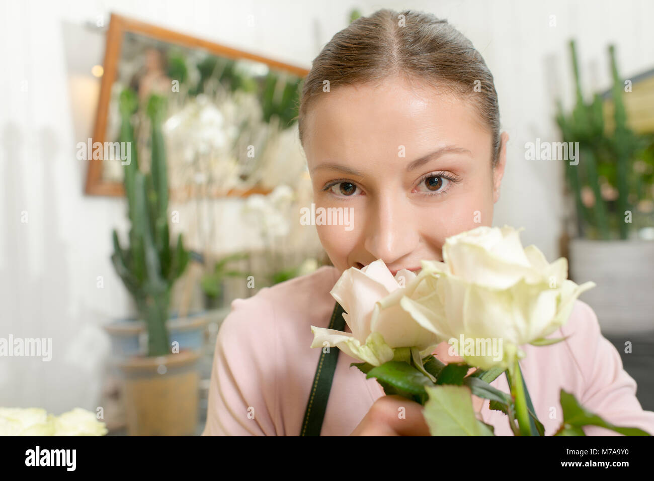 Florist smelling white roses Stock Photo Alamy