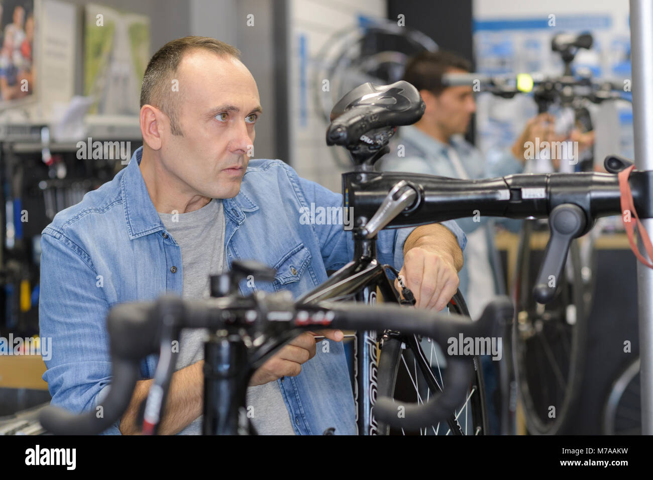 man checks a bike before buying in the sports shop Stock Photo