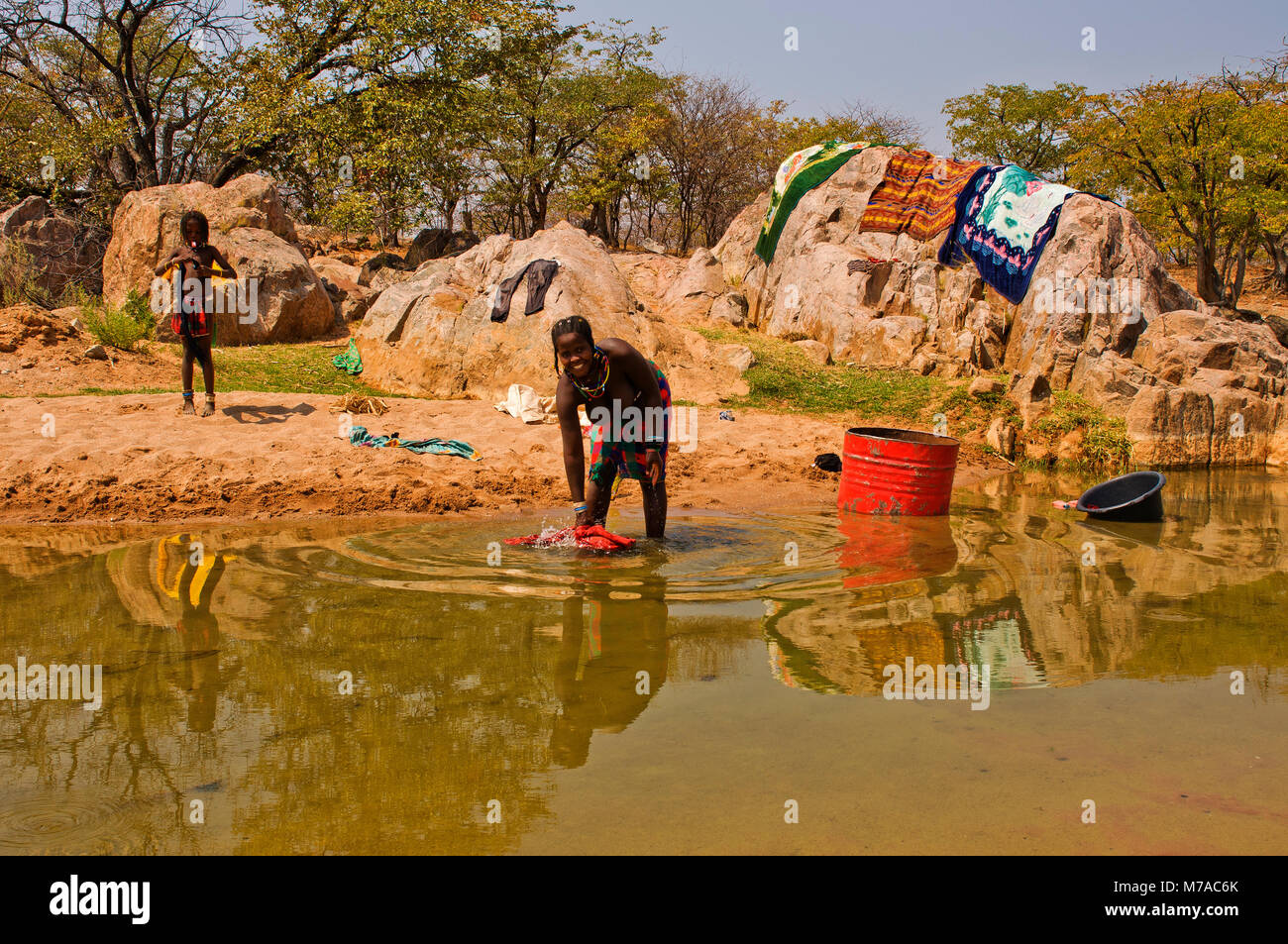 Inhabitants of northern Namibia washing clothes at a small river near Ehomba in the Kaokoland area, near the Angola border, Namibia Stock Photo