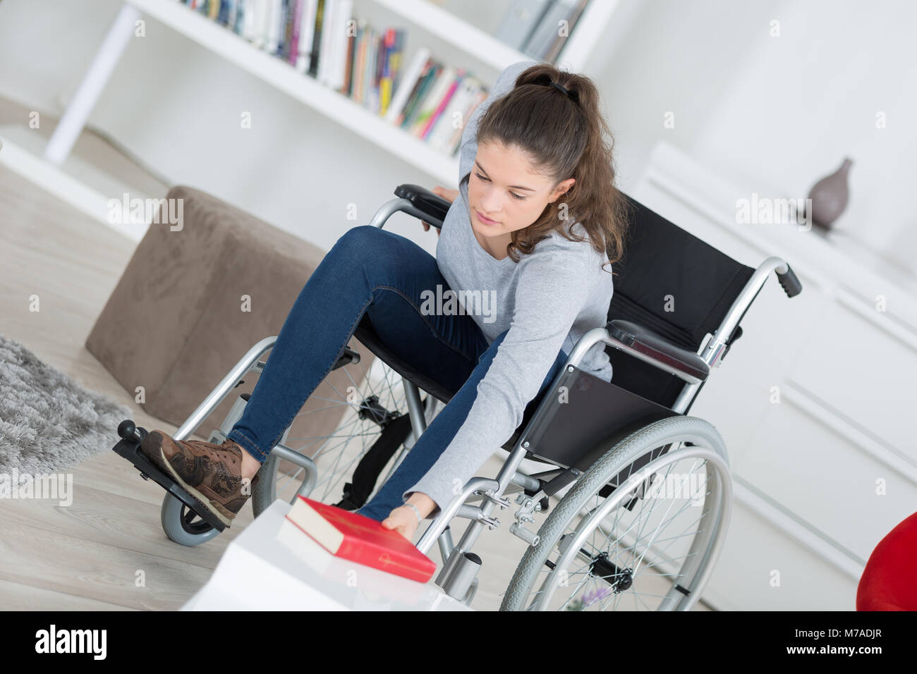 girl in wheelchair with book Stock Photo - Alamy
