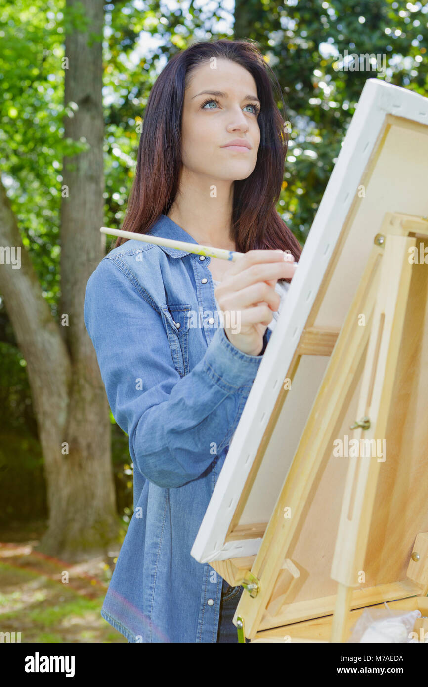 young female artist painting picture in park Stock Photo - Alamy