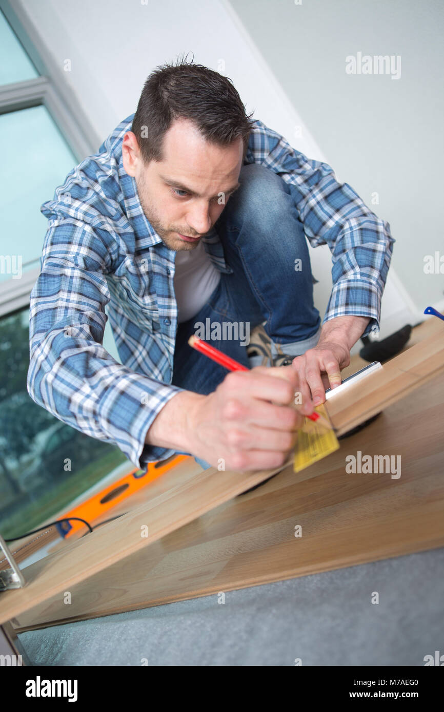 young man marking wood flooring with pencil and ruler Stock Photo - Alamy