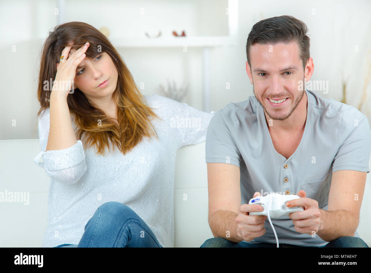 Happy boyfriend and girlfriend playing video games and holding