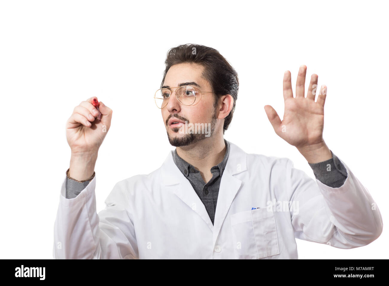 A man in a white coat with a red marker on a transparent glass. Stock Photo