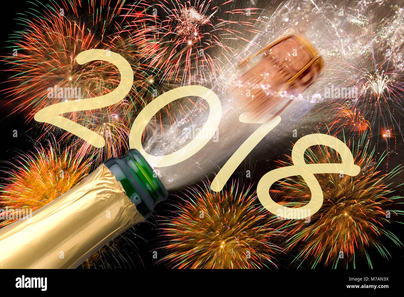 Popping champagne bottle with flying cork and brilliant fireworks at New Year's Eve in 2018 Stock Photo