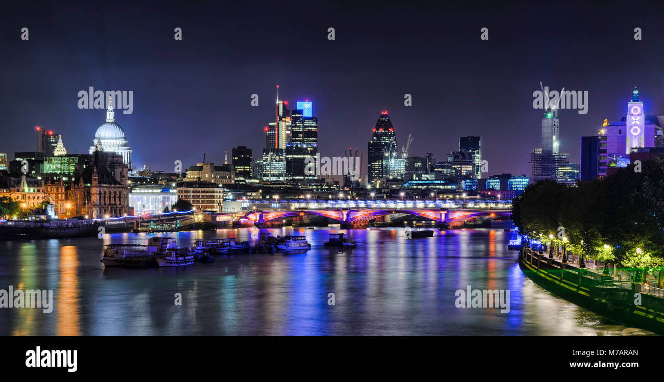 London skyline and Thames river at night, UK Stock Photo