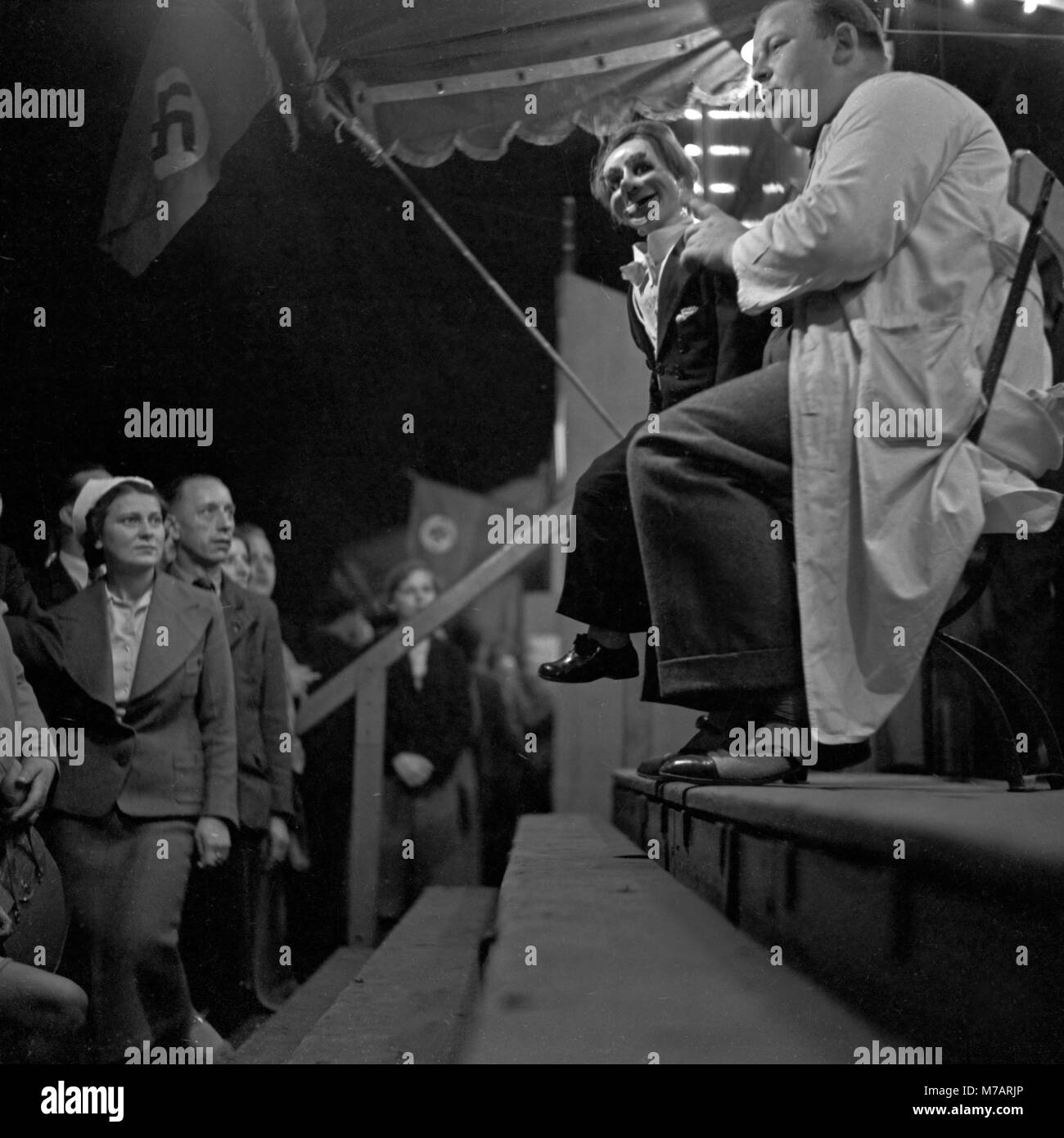 A ventriloquist and his dummy entertain their audience at the Berlin