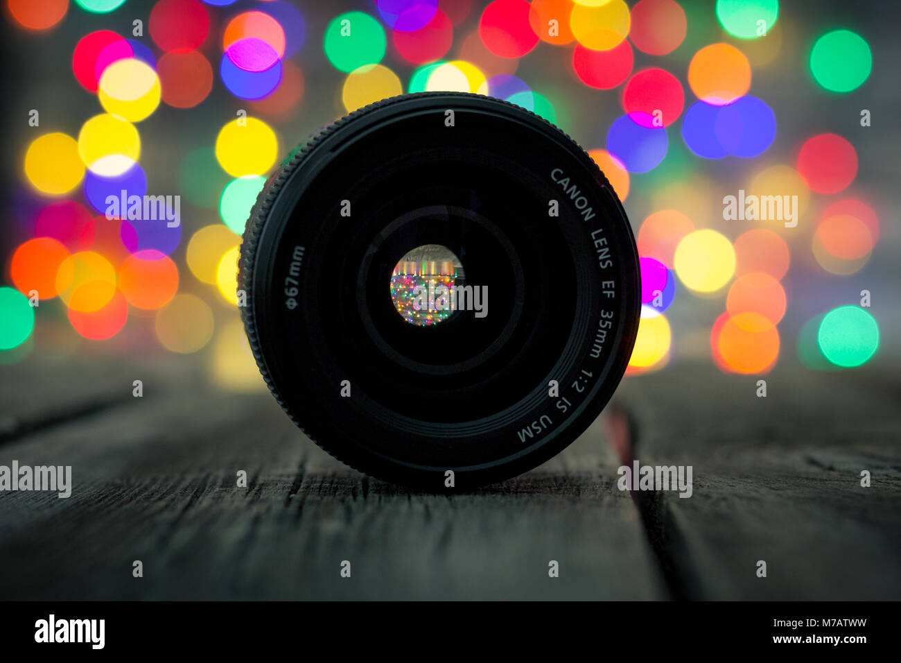 Close-up of the Canon EF 35 mm 1:2 IS USM lens with bokeh Christmas lights in the background Stock Photo