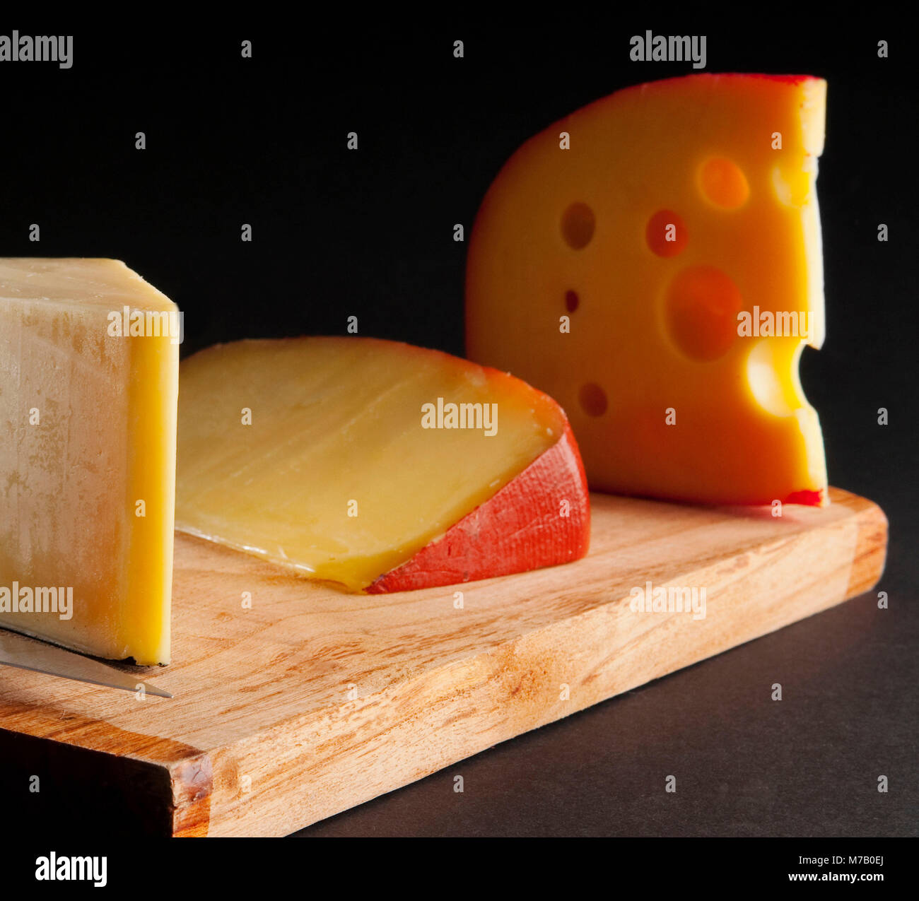 Assorted cheeses on a cutting board Stock Photo