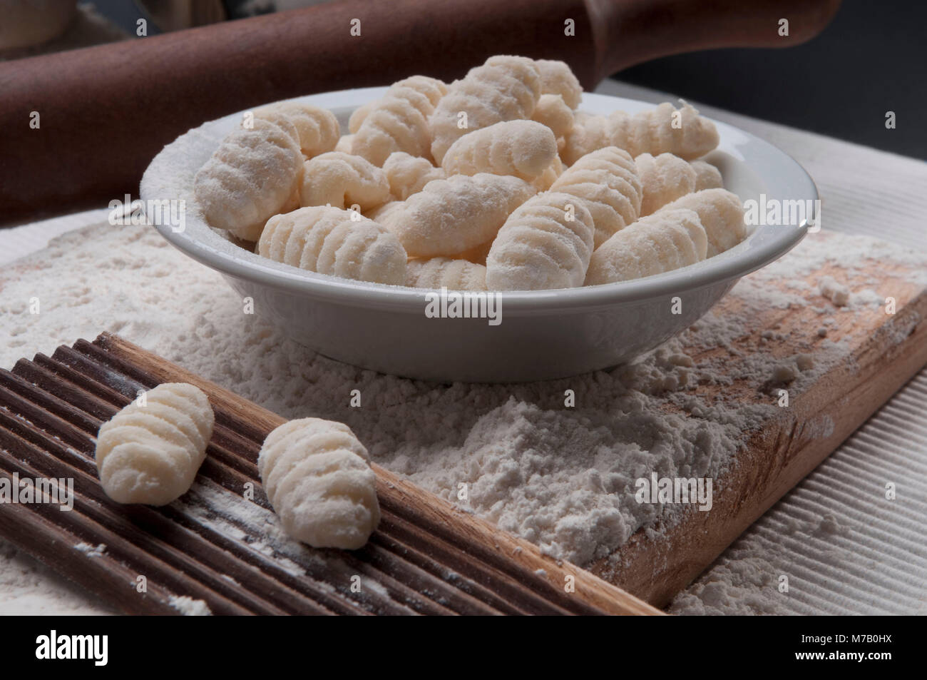 Bowl of homemade gnocchi with mould and a rolling pin Stock Photo