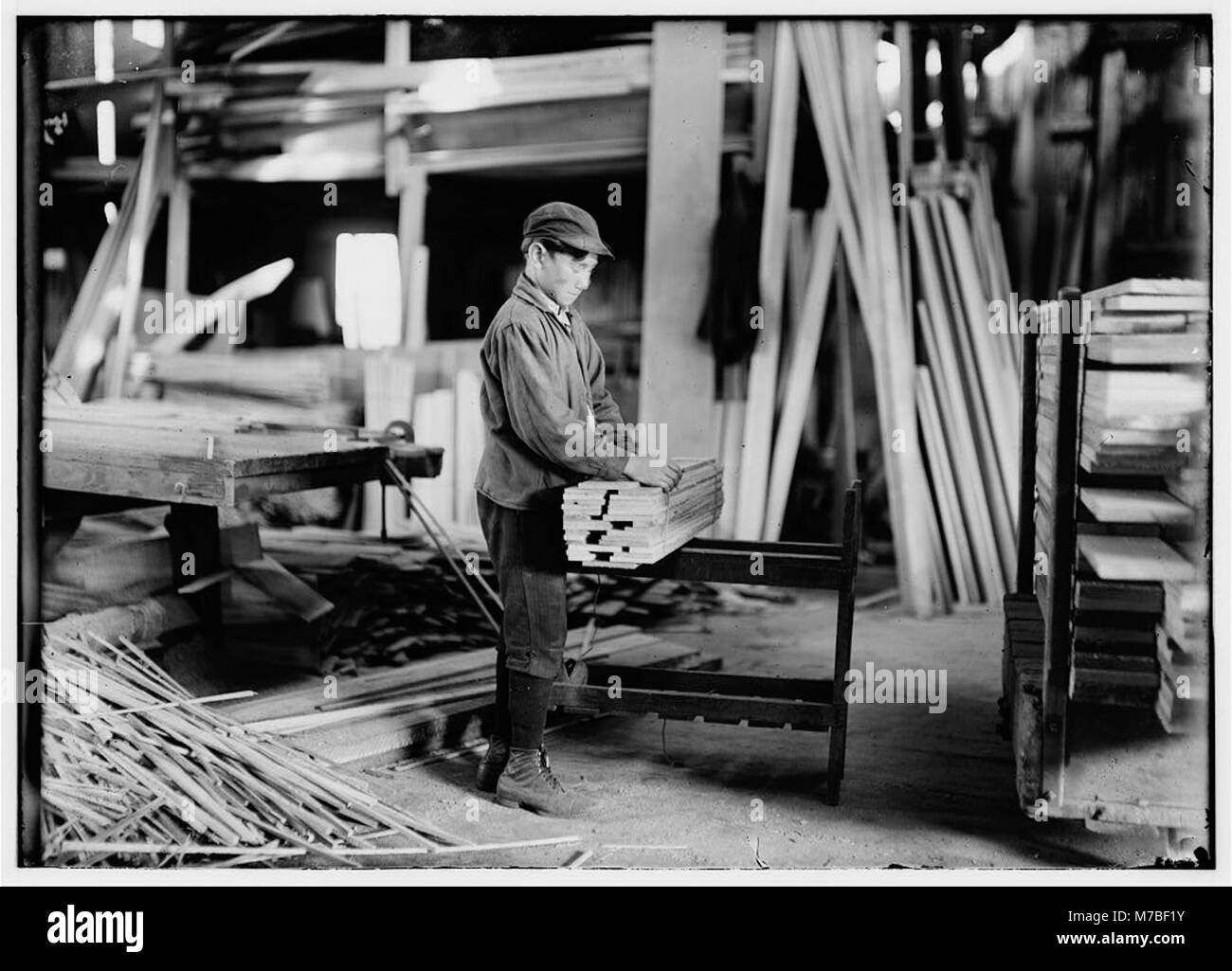 Boy probably about 13 years old, tying strips which he has taken away from the planer. Schultze Waltum Co., Planing Mill. LOC nclc.05372 Stock Photo