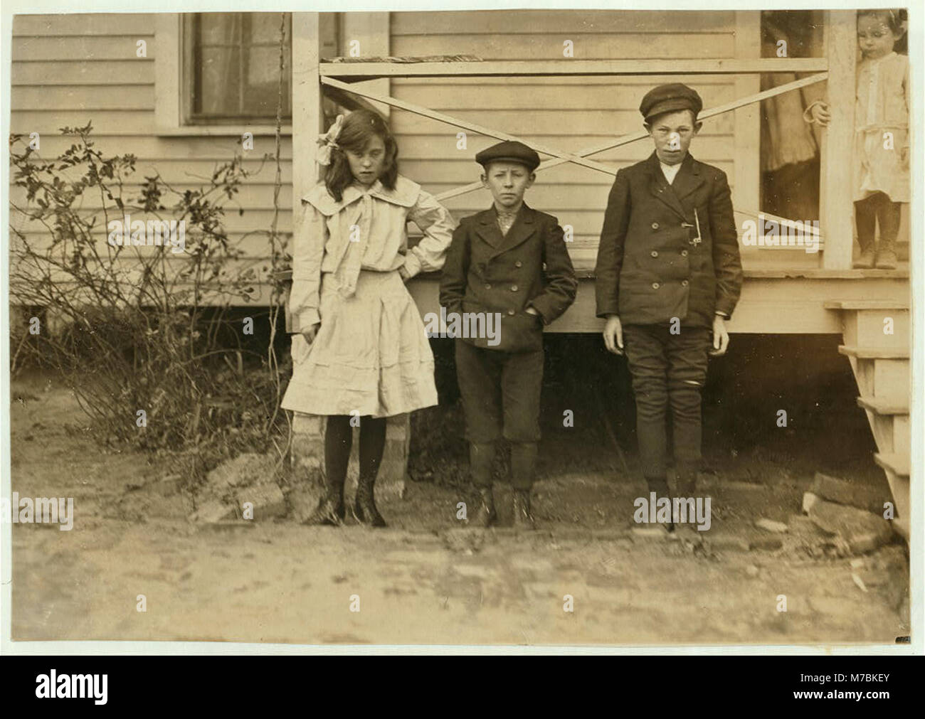Children of night superintendent, in Dickson Mill, Laurinburg, N.C. (1) Bessie Moore - runs 4 sides. Has worked two years nights. (2) Frank (smallest). Doffs. Has worked 2 yrs. nights. (3) LOC nclc.01505 Stock Photo