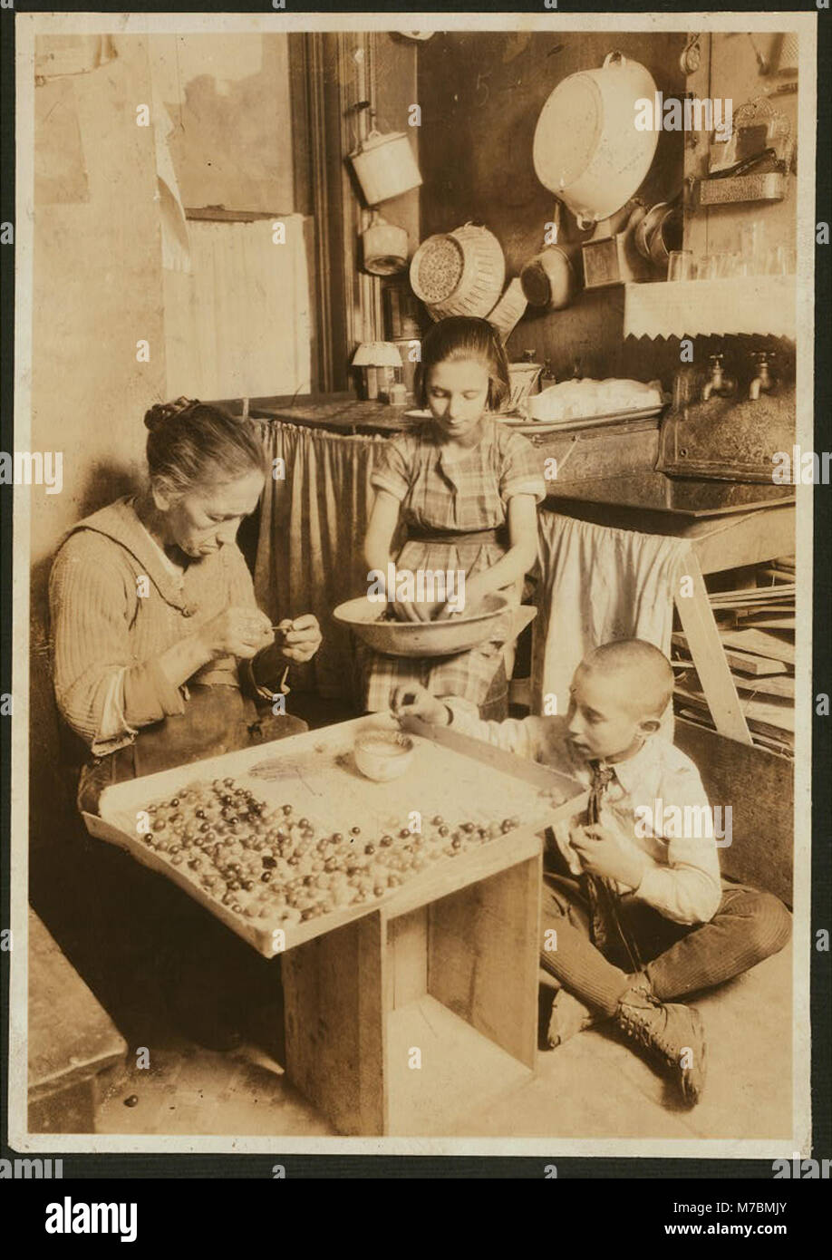 Coccaro, Angelina, 226 Thompson St., N.Y.C. Making Glass Flower Bulbs, earn about 75 cents to a $1.50 a day. Elizabeth age 10 yrs., and Frank age 8 yrs., very small and anemic. Taken by LOC nclc.04319 Stock Photo