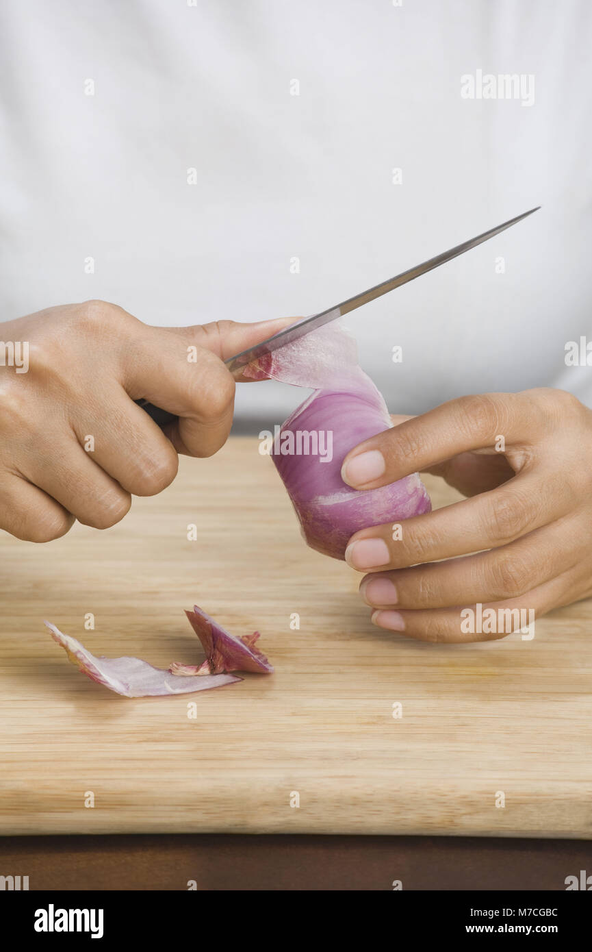 Mid section view of a woman peeling an onion Stock Photo - Alamy