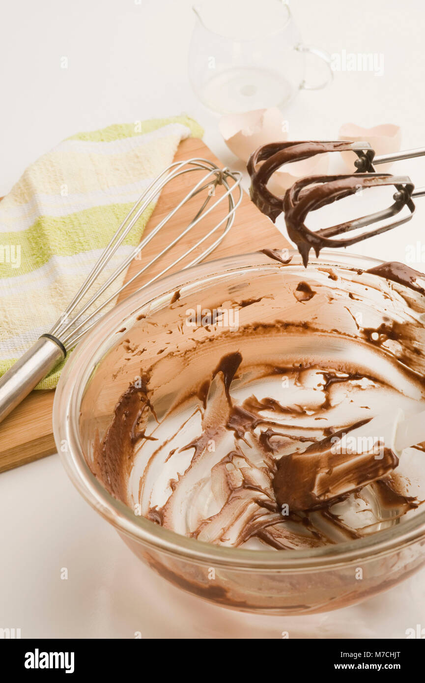 Chocolate sauce remains in a bowl with egg beaters Stock Photo