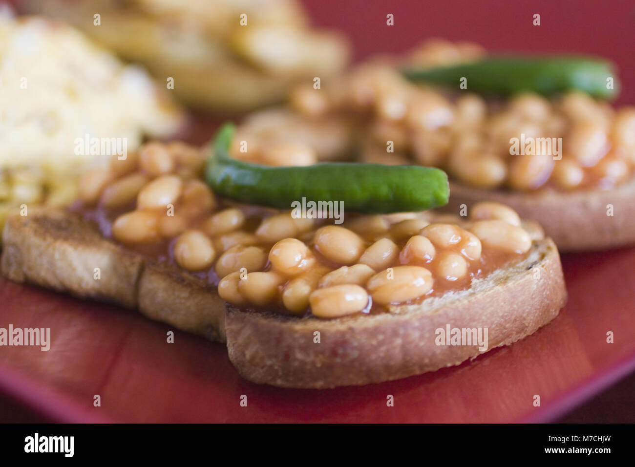 Closeup of baked beans on toasts with green chillies Stock Photo Alamy