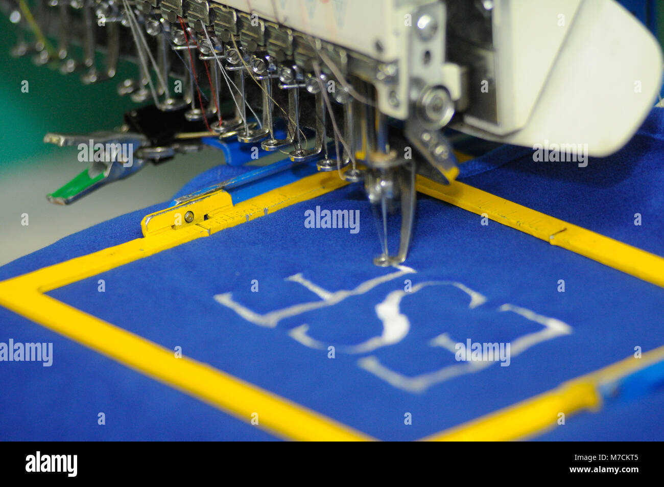 An embroidery machine close up stitching initials onto fabric Stock Photo