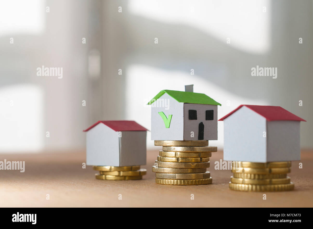 Mortgage and loan approved concept: paper houses on coin piles Stock Photo