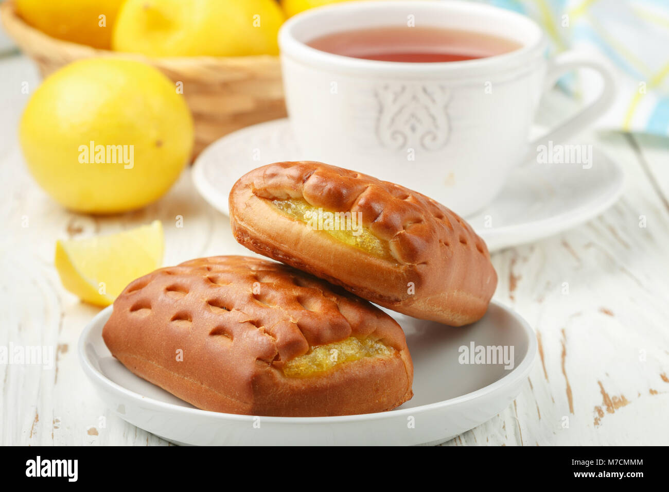 Traditionall Breakfast. Fresh homemade buns with lemon and tea. Rustic style. Selective focus Stock Photo