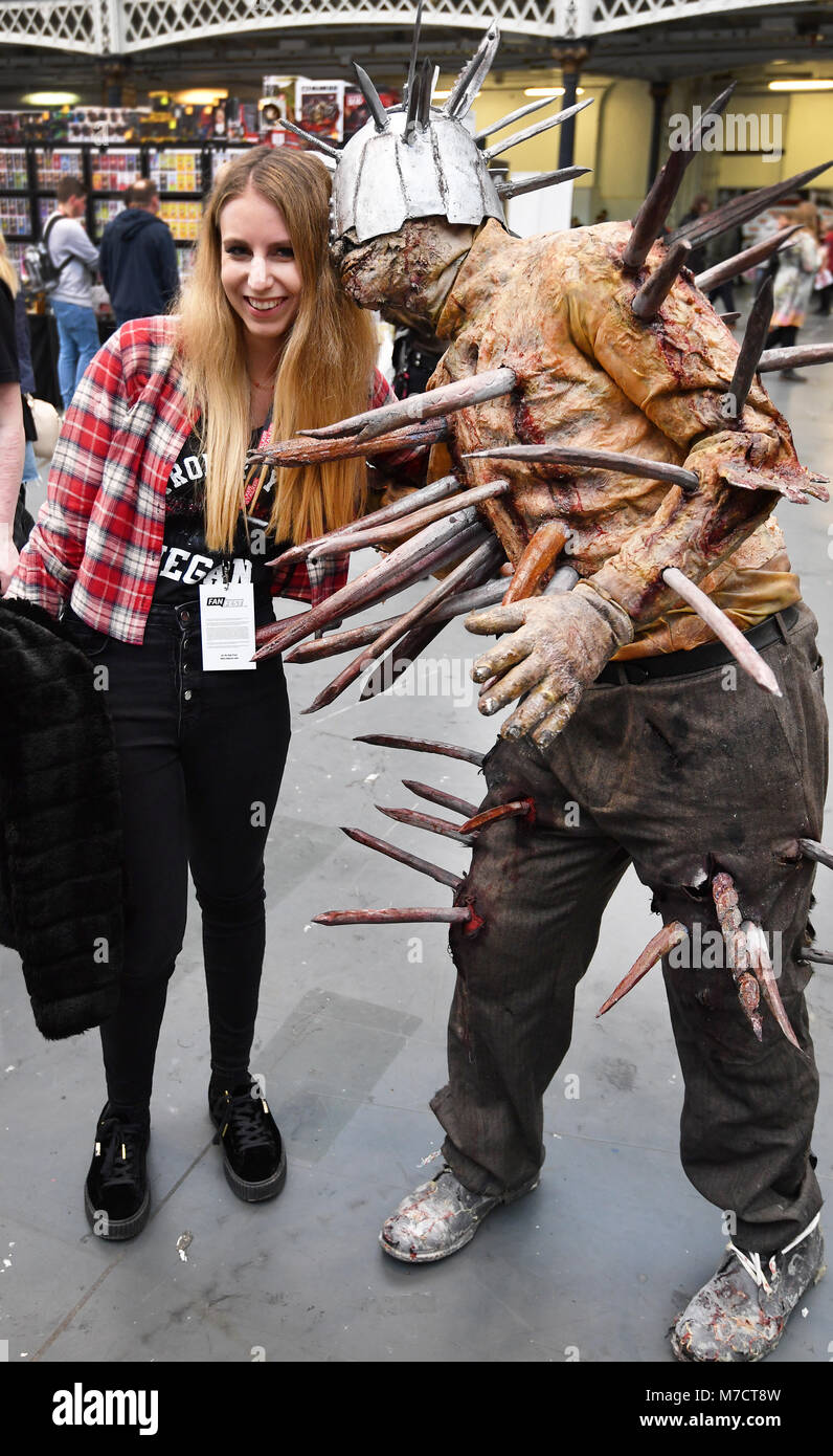 A visitor interacts with a character in costume at the Walking Dead convention, The Walker Stalker, at Olympia, London. Stock Photo