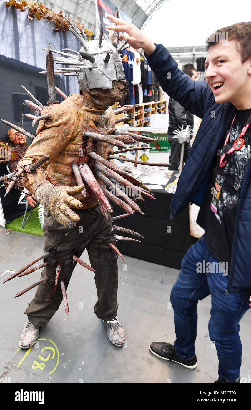 A visitor interacts with a character in costume at the Walking Dead convention, The Walker Stalker, at Olympia, London. Stock Photo