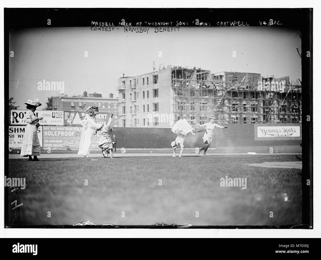 Girls doing cartwheels on playing field during contest for newsboys