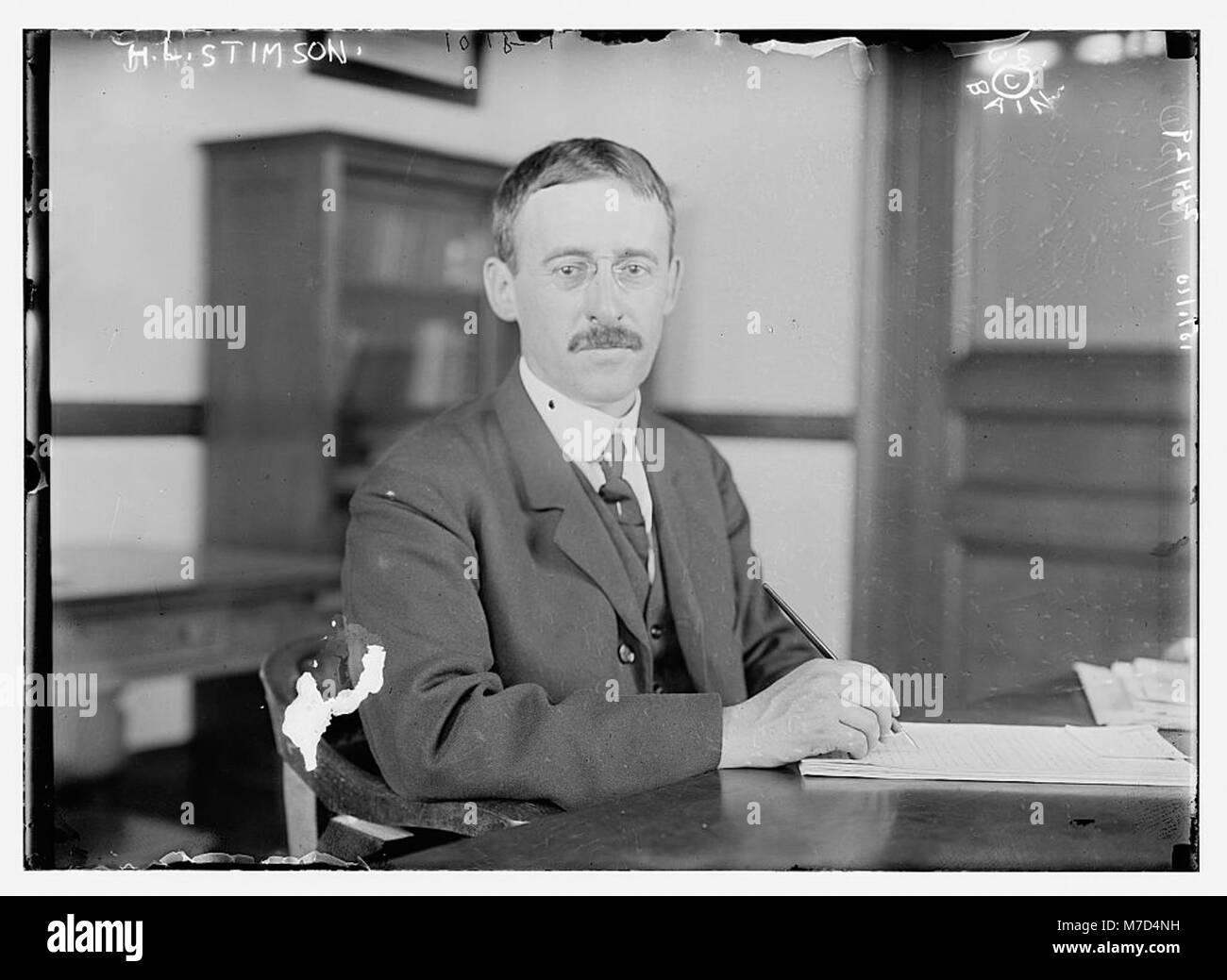 A historical photograph of H.L. Stimson, a U.S. statesman, seated at ...
