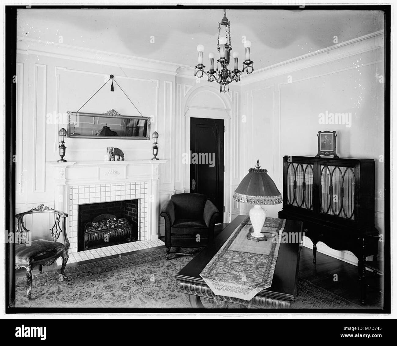 A photograph of a home interior, likely from the early 20th century ...