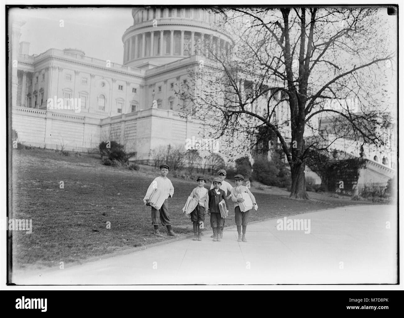 In comparison with governmental affairs newsies are small matters. This photo taken in the shadow of the National Capitol where the laws are made. This group of young newsboys sells on the LOC cph.3c22959 Stock Photo
