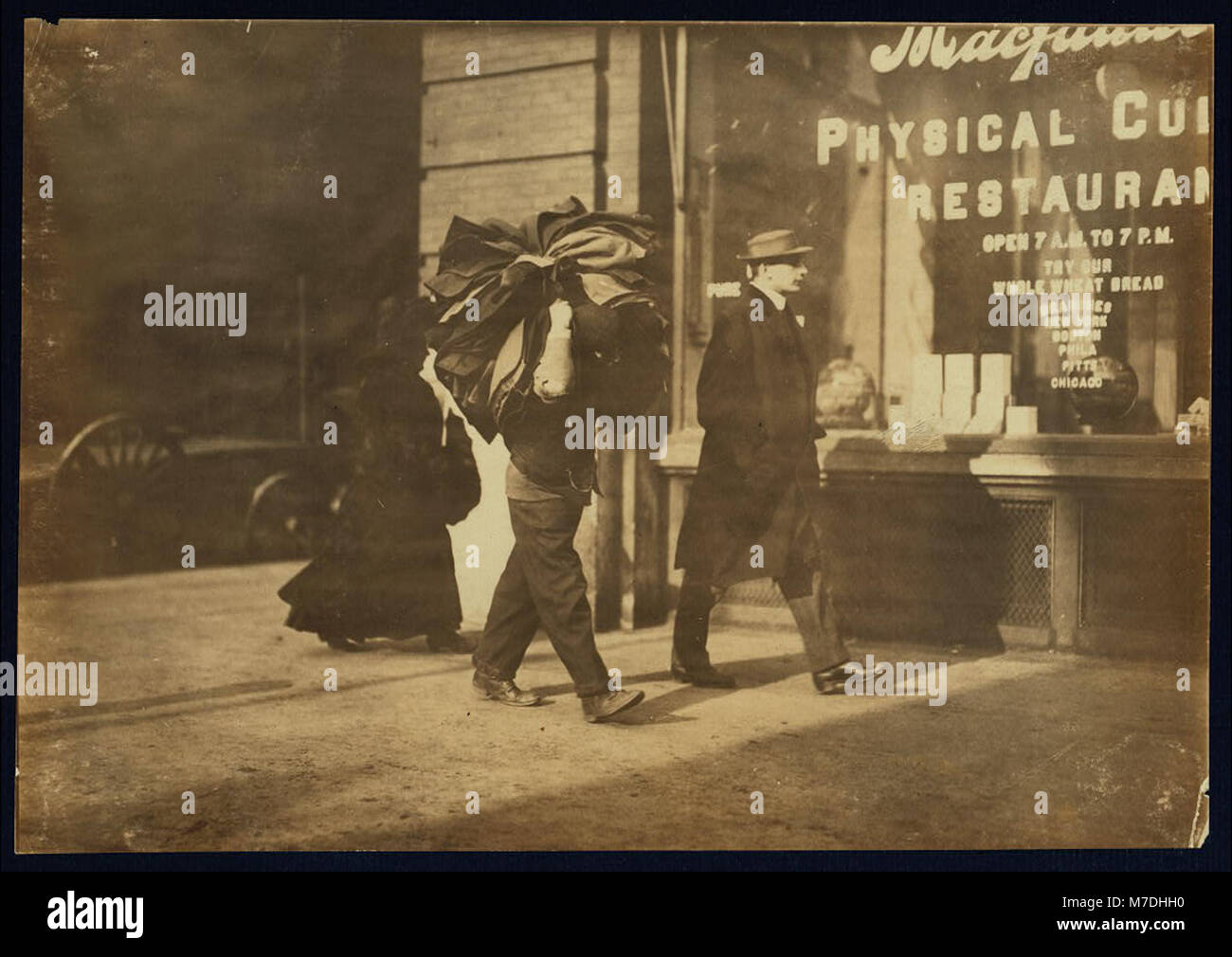 Man carrying bundle of garments. Bleeker St., N.Y. LOC nclc.04174 Stock Photo