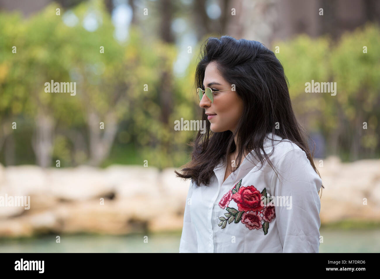 Beautiful Middle Eastern woman wearing sunglasses looking away at Madinat Jumeirah Dubai UAE Stock Photo