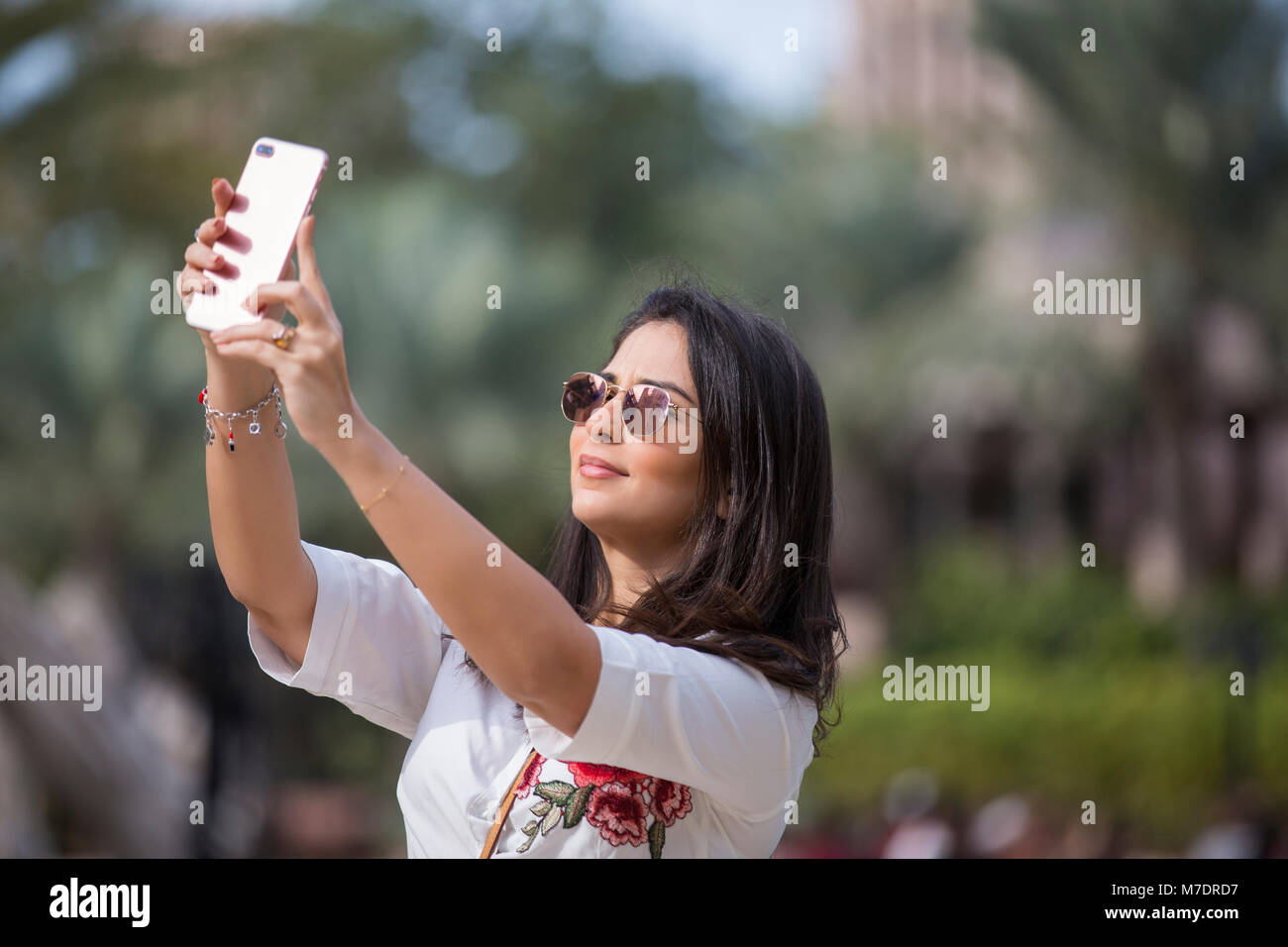 Beautiful woman taking a selfie picture with a mobile phone at Madinat Jumeirah Dubai UAE Stock Photo