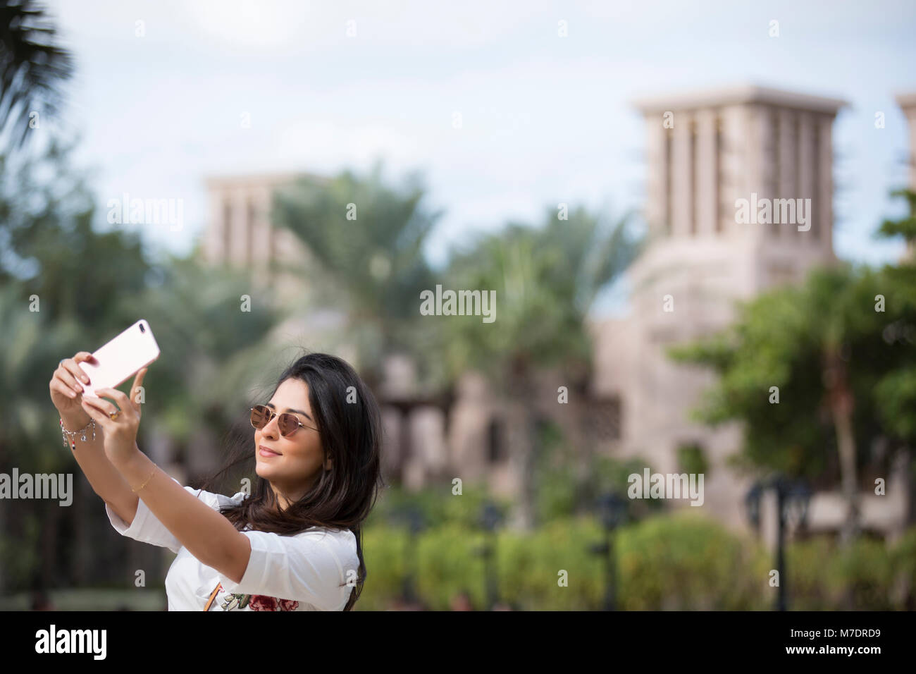 Beautiful woman taking a selfie picture with a mobile phone at Madinat Jumeirah Dubai UAE Stock Photo