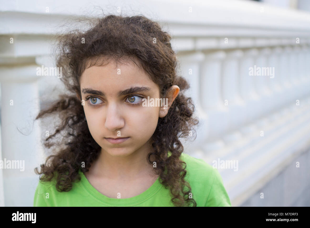 Worried Middle Eastern girl looking away outdoors Stock Photo