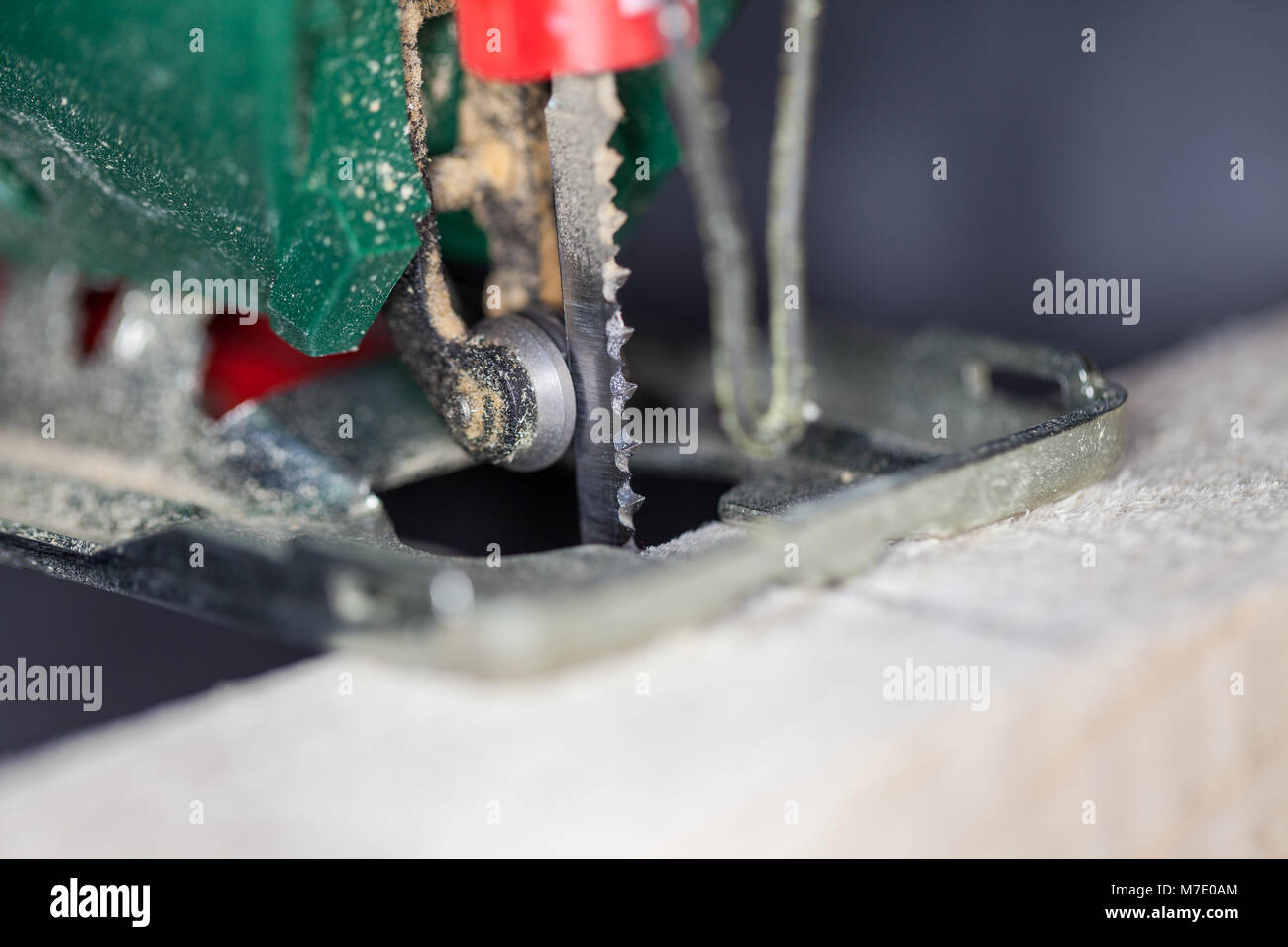 a green jigsaw saws a bright plank Stock Photo