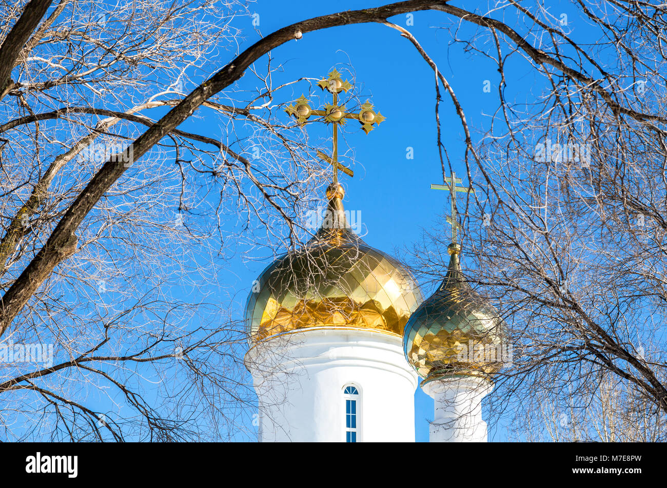 Domes of Russian orthodox church with golden cross against the blue sky ...