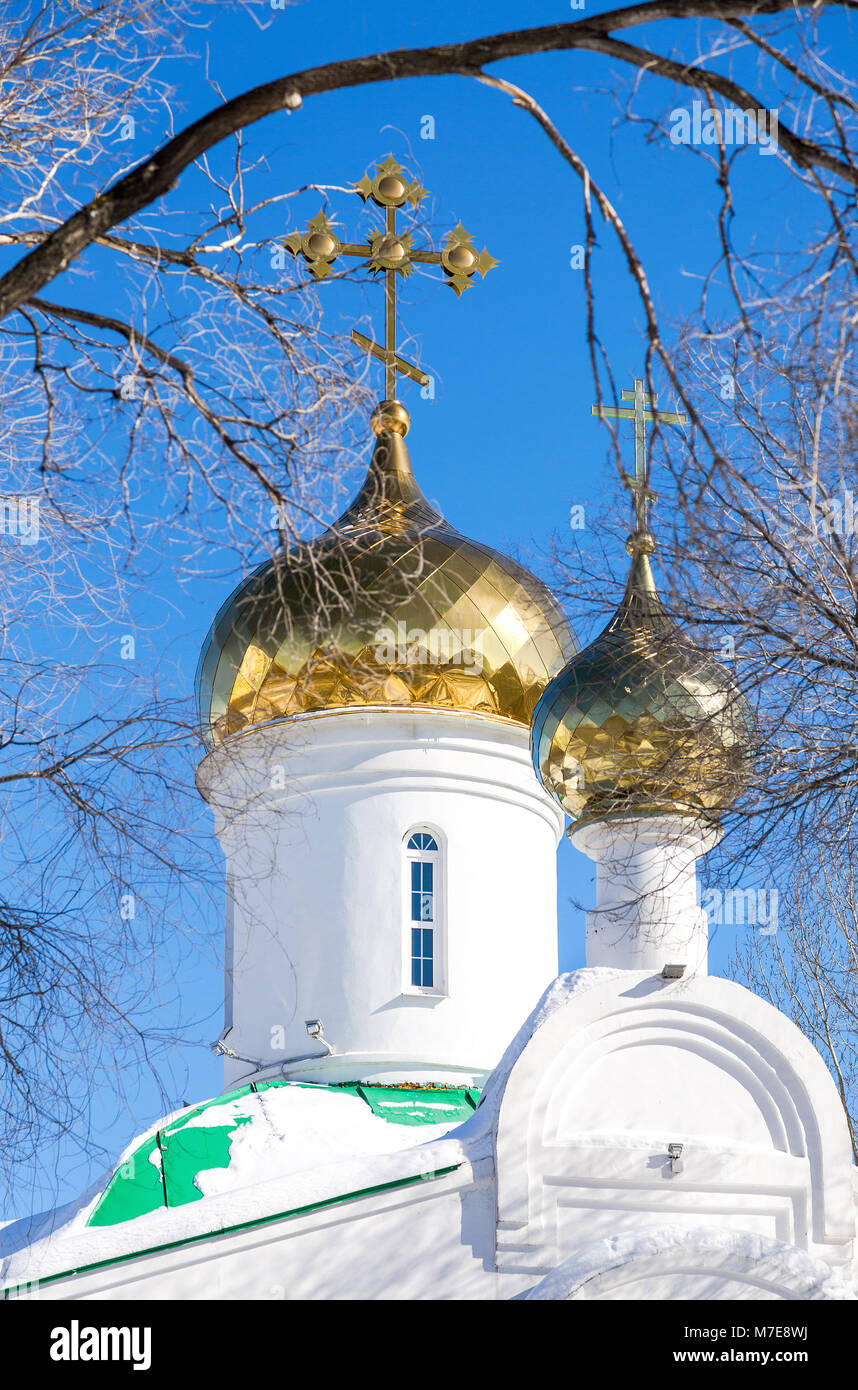 Domes of Russian orthodox church with golden cross against the blue sky ...