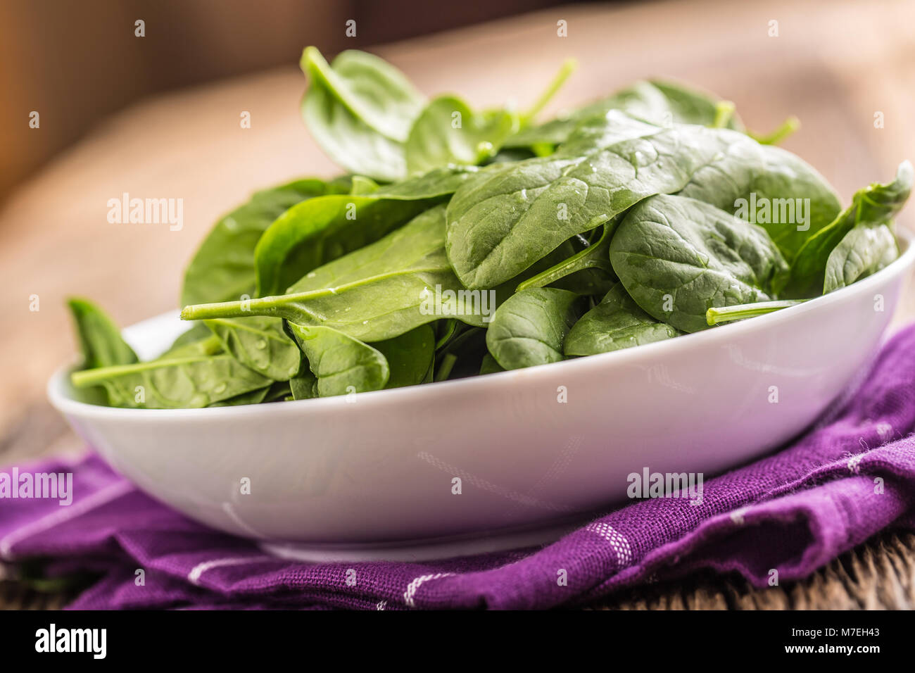 Spinach. Fresh baby spinach leaves in plate on woden table Stock Photo