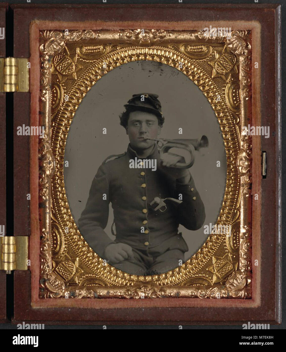 Private James E. Staley of Band Company, 9th Indiana Infantry Regiment, and Company B, 1st Indiana Heavy Artillery Regiment, holding a bugle to his mouth and carrying a revolver in his LCCN2011645433 Stock Photo