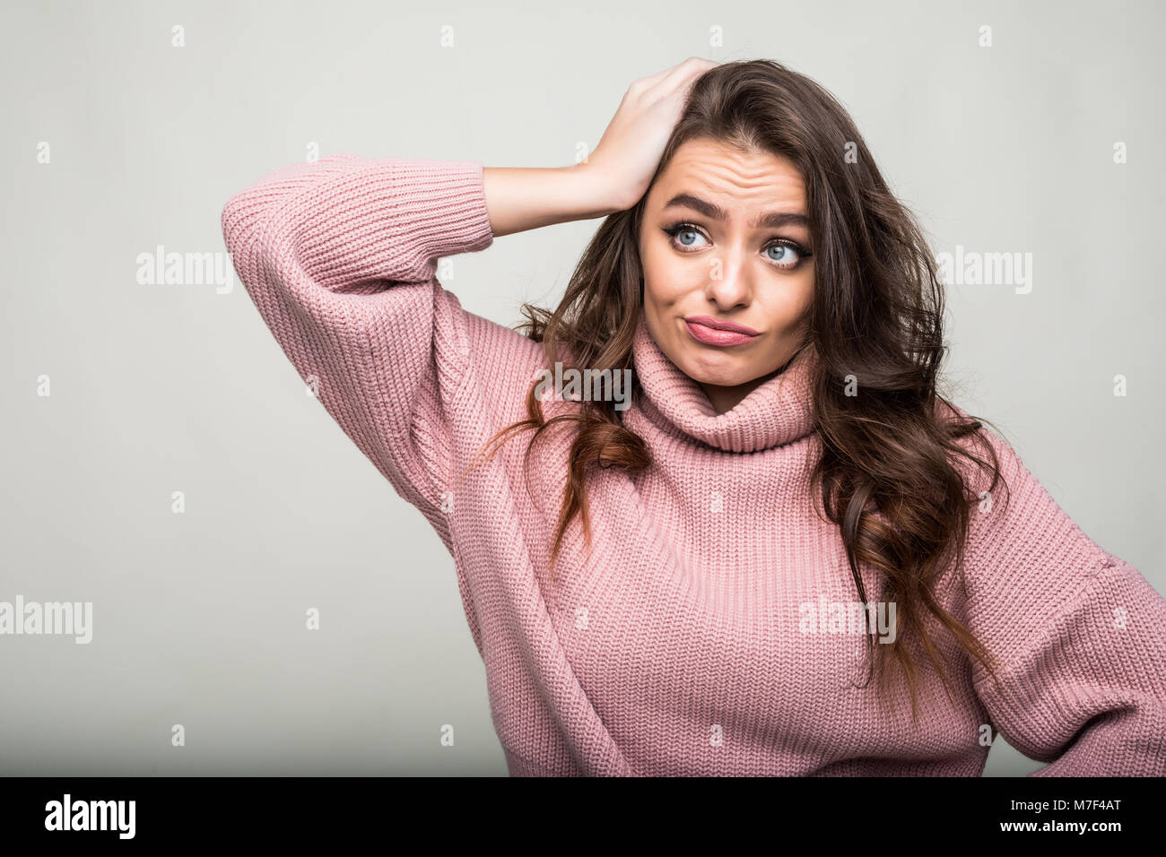 Lovely confused woman isolated against white background Stock Photo