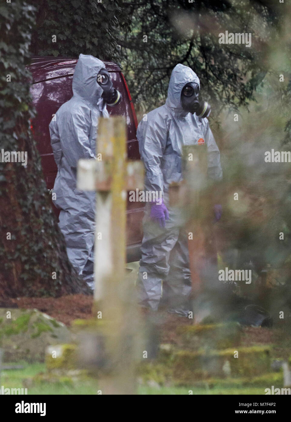 Forensic officers in gas masks at the London Road cemetery in Salisbury, Wiltshire, as investigations continue at the cemetery where former Russian double agent Sergei Skripal's wife and son were laid to rest. Stock Photo
