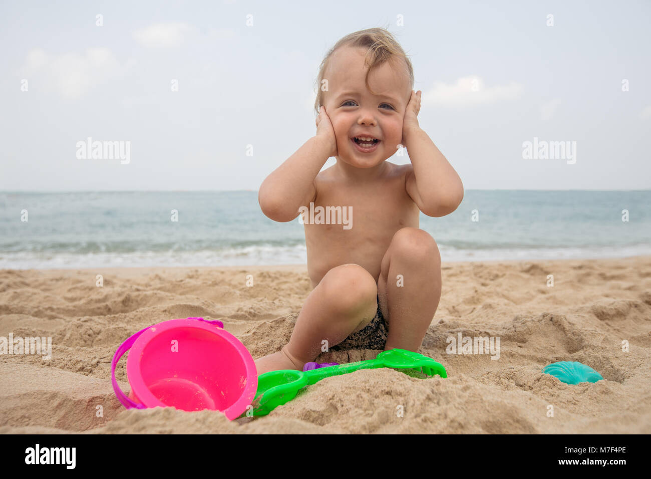 Adorable infant on sandy beach Stock Photo